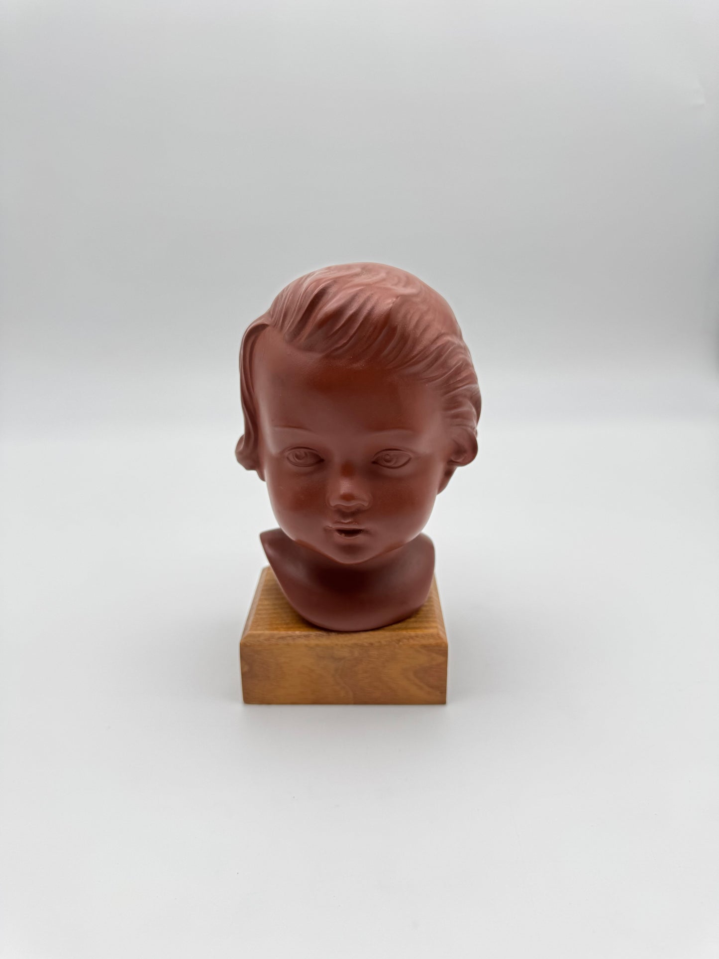 Terracotta kinderhoofdje op houten sokkel